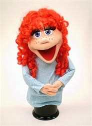Rubee is a female puppet with a real human style red wig, peach skin and red freckles.