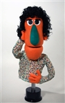 This 24" inch tall woman puppet is orange with black curly hair.