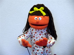 Tiny hand puppet girl with orange skin and brown ponytail.
