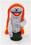 Priscilla is a lavender girl puppet with orange pigtails.