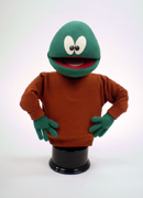 Green puppet with unusual eyes and bald head.
