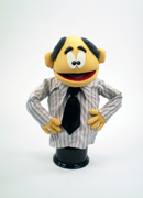 Yellow man puppet with salt and pepper balding hair and long sleeve shirt and tie.